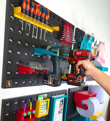 Hand Placing Milwaukee Drill on Wall, next to Makita and DeWalt Electric Drills