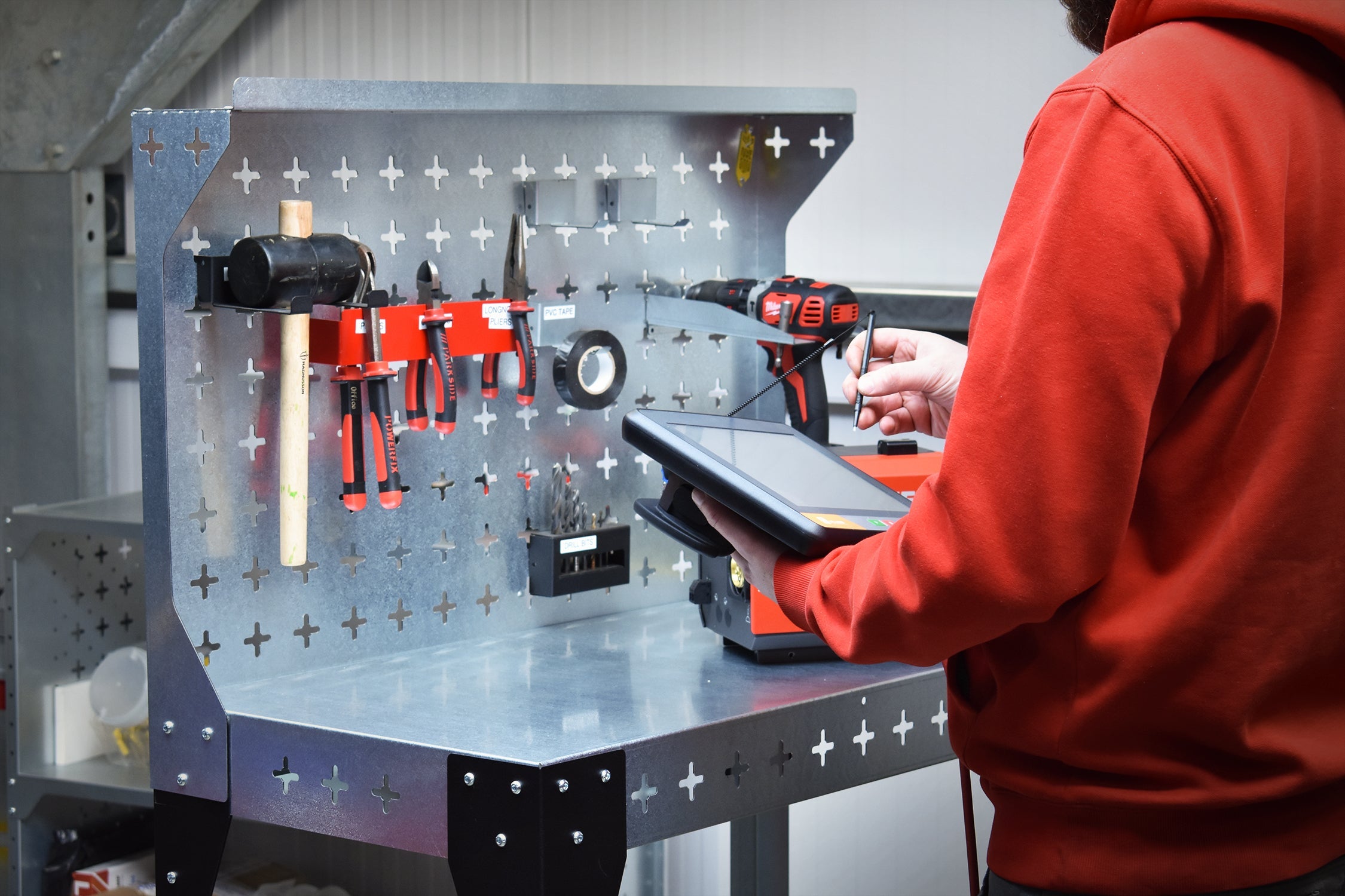 Man operating the welding robot tablet next to the Nukeson Trolley.