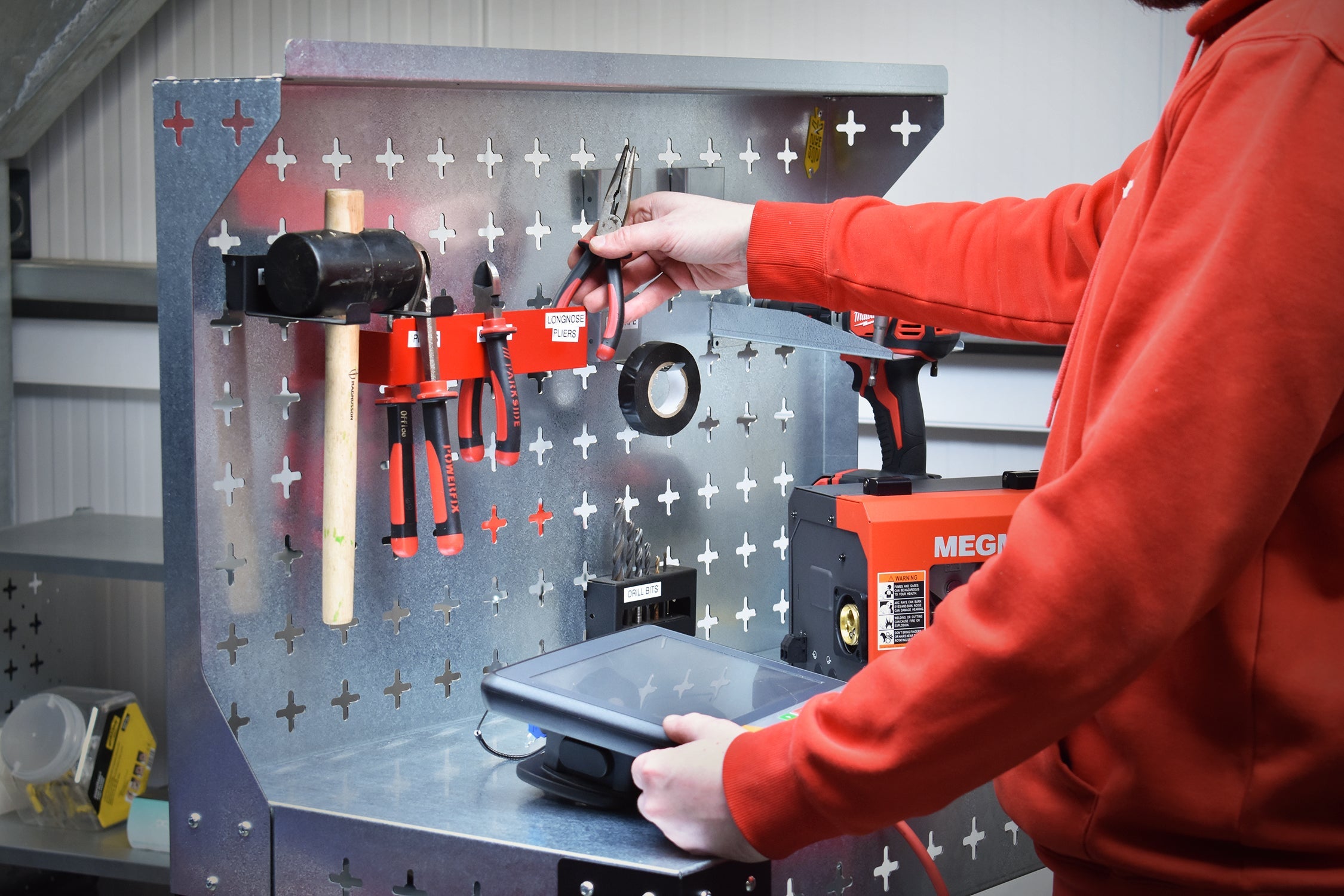 Man removing tools from the back wall of the Nukeson Industrial Trolley